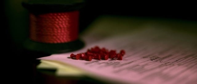 a spool of thick red rope, next to a small pile of thick red push pins. Lying on a pile of police paperwork that is out of focus. Close up. Moody photo. --ar 7:3 --sref 2543085458 --v 8.2 Job ID: e2371fa8-8794-4f6f-94be-4c82ef810d26